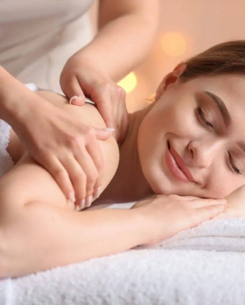 Massage des épaules sur une table garnie de serviettes